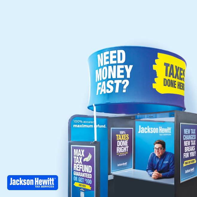 A man sitting in a Jackson Hewitt kiosk booth.